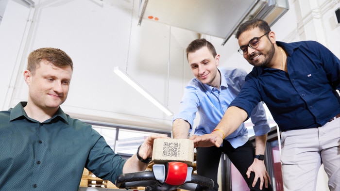 A pallet block with a QR code is being examined during a workshop activity.