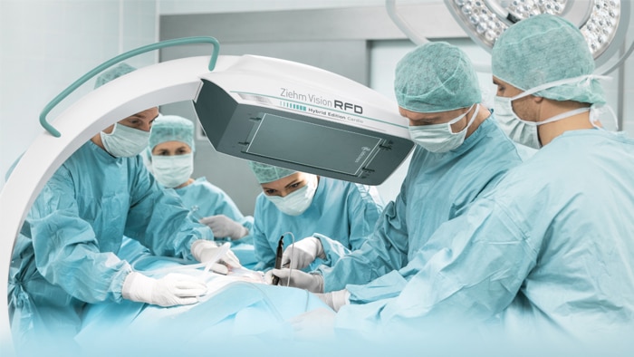 An operating team is working in the operating room with a mobile C-arm from Ziehm Imaging for intraoperative imaging